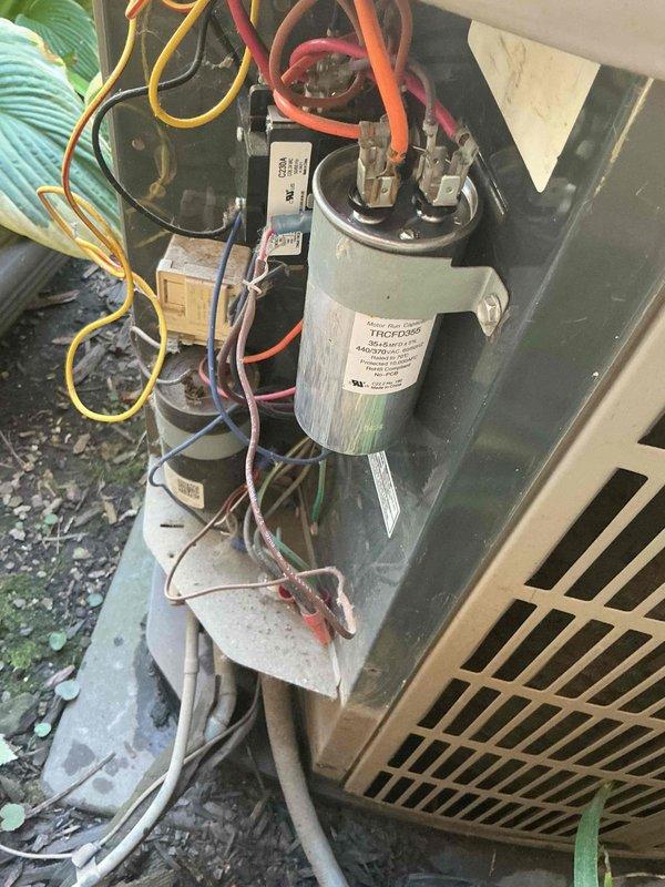 # HVAC Cooling System Repair

Responded to service call for one of two air conditioning units not operating at residential property. Unit is a 9-year-old system experiencing complete failure to cool.

## Diagnostic Findings

Upon arrival, performed visual inspection of outdoor condensing unit. System showed no signs of power to compressor or condenser fan motor. Removed access panel to electrical compartment and conducted voltage testing at contactor and capacitor terminals.

Identified failed dual-run capacitor as root cause of system failure. Capacitor tested at zero microfarads on both common-to-compressor and common-to-fan terminals, well below manufacturer specifications. Visual inspection of capacitor revealed bulging case and discoloration on terminal connections, indicating internal component failure.

## Repairs Performed

Disconnected power to unit at disconnect box. Safely discharged residual voltage from failed capacitor. Removed defective dual-run capacitor from mounting b