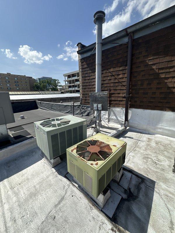 Conducted site assessment for commercial AC equipment replacement. Inspected two existing aged rooftop condenser units showing significant weathering and deterioration, documented current equipment configuration including electrical disconnects and ductwork routing. Evaluated basement mechanical room with two corresponding air handling units and associated ductwork to determine spatial requirements and equipment specifications for new system installation estimate.