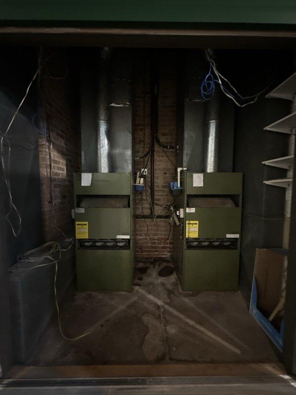 Conducted site assessment for commercial AC equipment replacement. Inspected two existing aged rooftop condenser units showing significant weathering and deterioration, documented current equipment configuration including electrical disconnects and ductwork routing. Evaluated basement mechanical room with two corresponding air handling units and associated ductwork to determine spatial requirements and equipment specifications for new system installation estimate.