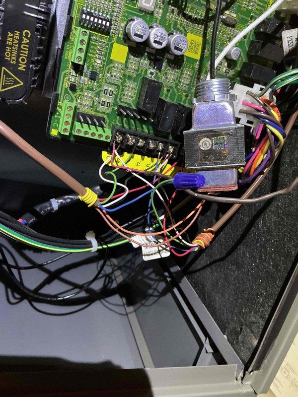 # Warranty Maintenance Recall Completed

Performed warranty recall service on HVAC system control board assembly. Accessed main control panel and inspected electronic control unit containing primary green PCB with integrated circuits, capacitors, and terminal connections. Verified proper operation of control board components including multiple ICs, electrolytic capacitors, and wire terminations at yellow terminal blocks. 

Examined complex wiring harness arrangement with multiple colored conductors connected to terminal blocks and verified secure connections throughout. Inspected secondary control boards mounted vertically in enclosure, confirming all electronic components, traces, and field wiring connections met manufacturer specifications. All circuit boards showed proper manufacturing quality with organized component placement and secure mounting within black housing.

Verified electrical safety warnings and labels were intact and legible. Confirmed all wire bundles, connectors, an