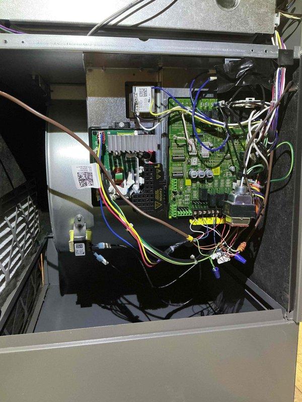 # Warranty Maintenance Recall Completed

Performed warranty recall service on HVAC system control board assembly. Accessed main control panel and inspected electronic control unit containing primary green PCB with integrated circuits, capacitors, and terminal connections. Verified proper operation of control board components including multiple ICs, electrolytic capacitors, and wire terminations at yellow terminal blocks. 

Examined complex wiring harness arrangement with multiple colored conductors connected to terminal blocks and verified secure connections throughout. Inspected secondary control boards mounted vertically in enclosure, confirming all electronic components, traces, and field wiring connections met manufacturer specifications. All circuit boards showed proper manufacturing quality with organized component placement and secure mounting within black housing.

Verified electrical safety warnings and labels were intact and legible. Confirmed all wire bundles, connectors, an