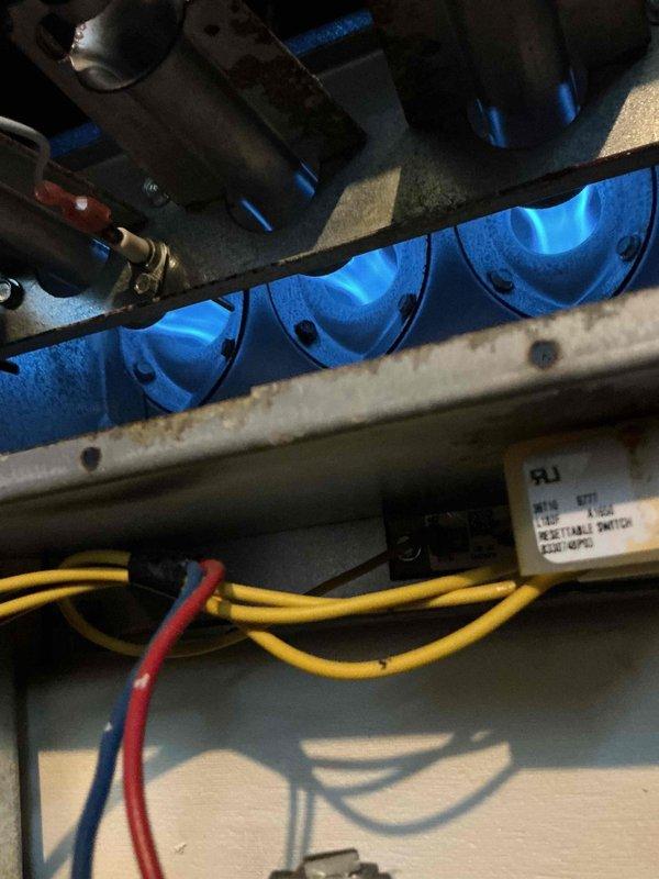 Replaced defective inducer motor on gas furnace heating system. Verified proper burner ignition sequence with blue flame pattern across all burners. Inspected and evaluated flame sensor condition during service, confirming proper operation of safety components. Collected photographic documentation of operational burners and flame sensing equipment. Part was obtained from supply house for installation. Confirmed all electrical connections secure and system returned to normal heating operation with proper burner flame and safety controls functioning as designed.