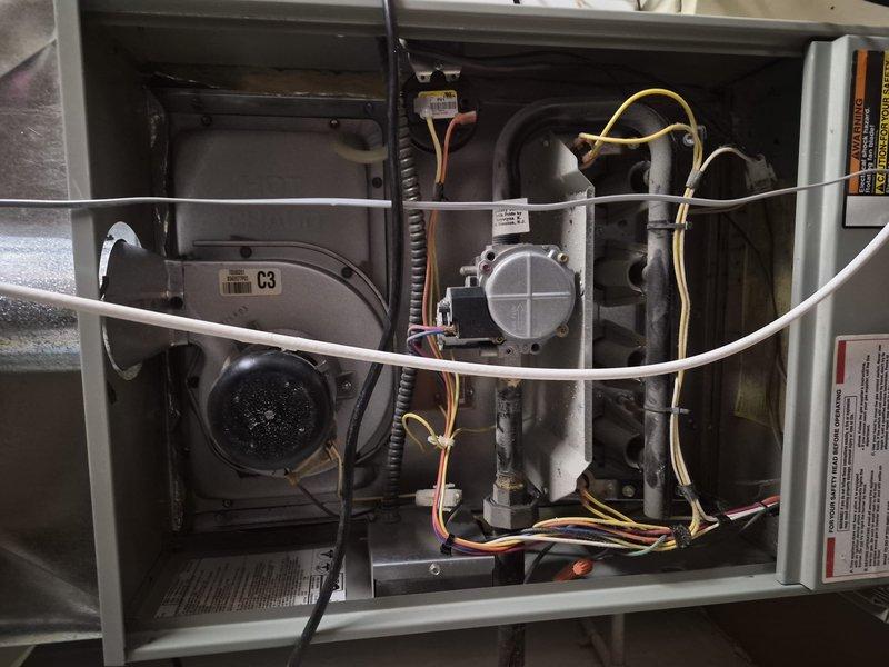 Responded to no cooling complaint and performed diagnostic inspection of HVAC system. Removed access panel to inspect internal components including blower motor, gas valve assembly, and electrical connections. Documented equipment information and photographed system components for service records.