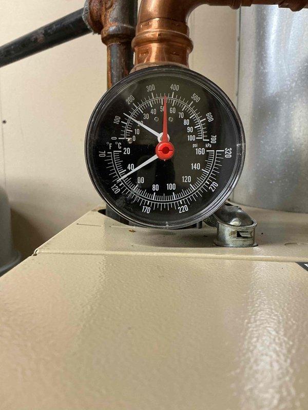 Replaced failed expansion tank on hydronic heating system. Removed old corroded unit showing significant rust on pipe fittings and connections, installed new expansion tank with proper pressure gauge and verified system pressure within manufacturer specifications. Documented installation with photos showing completed work and proper gauge readings.