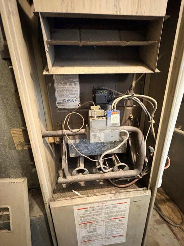 Performed a prepaid commercial maintenance visit on an upright gas furnace, inspecting the burner compartment, gas valve and manifold assembly, and associated wiring, and noting heavy dust and debris accumulation on the burner tubes and cabinet along with loosely routed control wiring. Inspected the fiberglass air filter, which showed dust loading, and documented the equipment data plate and filter information, with any required changes flagged for update to the filter list.