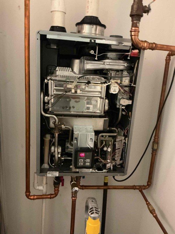 Diagnosed a tankless water heater displaying Error Code 12 (flame failure/no flame detection), a recurring fault. Inspected the burner assembly, flame rod, and flame sensor circuit, serviced the ignition and flame-sensing components, and verified a stable flame signal. Confirmed proper operation with the unit firing and delivering hot water at the set temperature of 135°F.