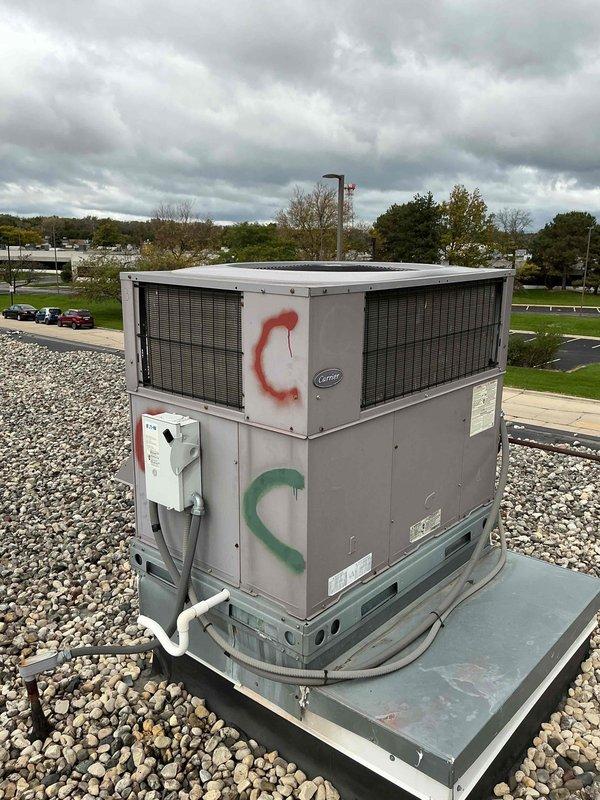 Replaced the failed gas valve on RTU #3, a Carrier packaged rooftop unit, and verified proper gas valve operation and burner ignition after installation. The burner compartment showed heavy corrosion, rust on the tray and brackets, and soot staining on the burner tubes, indicating aged components that may warrant further evaluation.