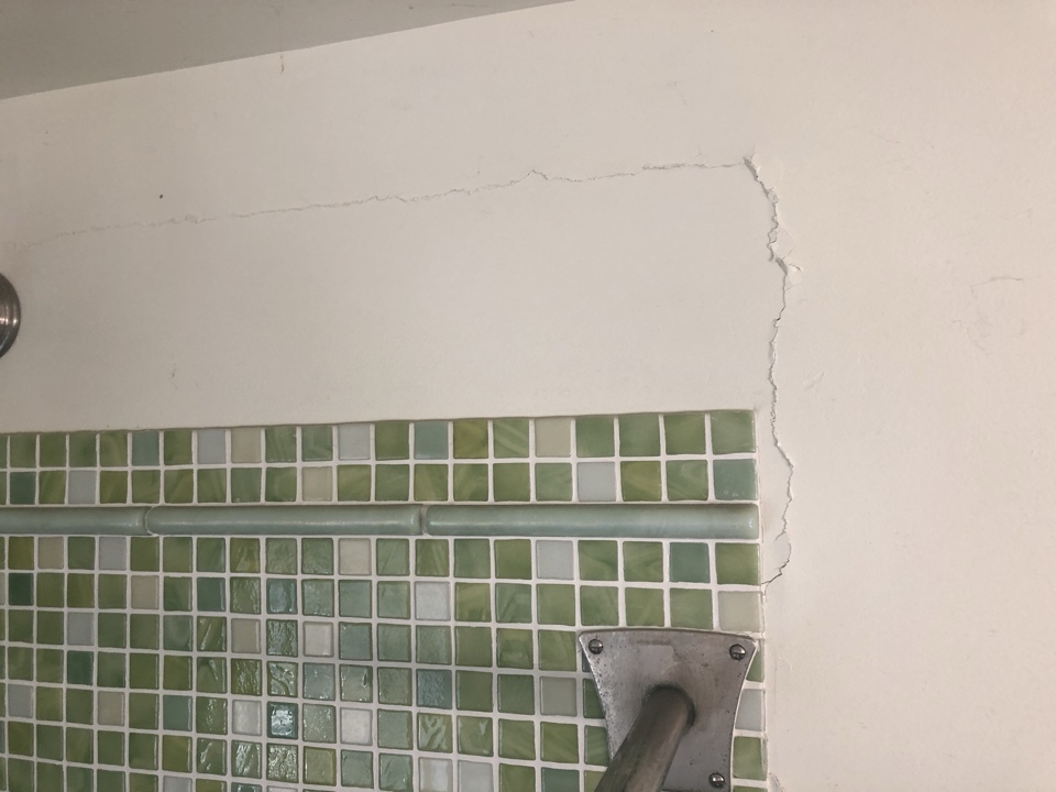 Minor settlement cracks in bathroom drywall.