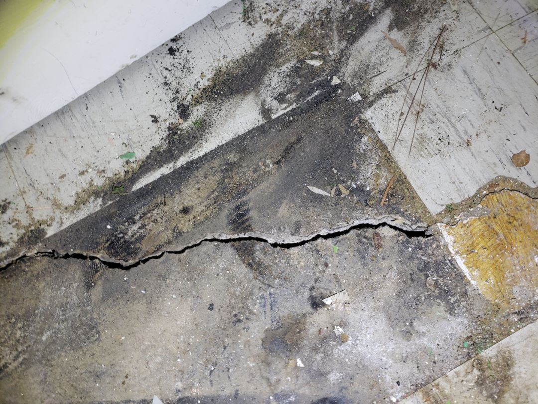 Settlement of -1.6" causing a cracked slab.