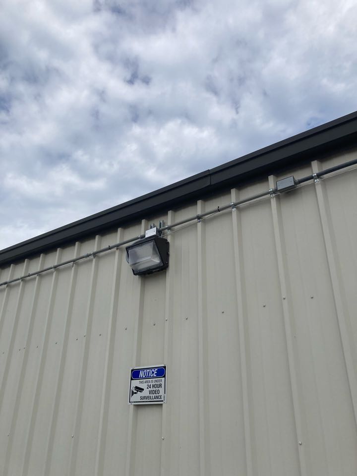 LED wall packs with built-in photocell. Installed over man door and parking area at a commercial building. Provides bright and efficient lighting