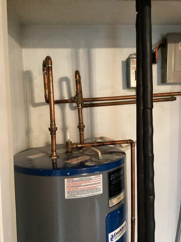 Performed diagnostic assessment of reported T&P valve leak on customer's Everhot tanked water heater. Inspected copper piping connections and valve assembly at top of unit. No active leaks were detected at the temperature and pressure relief valve or surrounding fittings. System appears to be operating normally with proper installation of discharge tube.