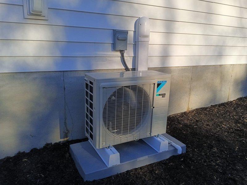 Successfully installed a Daikin Mini Split System with proper outdoor condenser placement on a stable pad. System was fully connected with appropriate electrical wiring and PVC condensate drainage. Post-installation testing confirmed optimal temperature output with readings at 70.3°F, verifying the system is operating within manufacturer specifications.