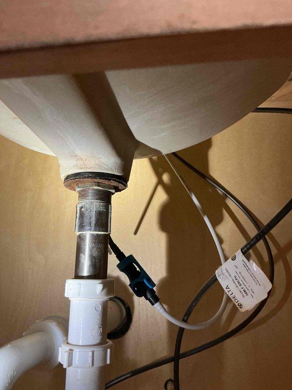 Responded to callback for previously repaired sink that continued leaking. Inspected the metal drain assembly and discovered improper seal between threaded metal drain pipe and PVC P-trap connection. Resealed connection points and performed water test to verify resolution. No fee charged for this warranty service.