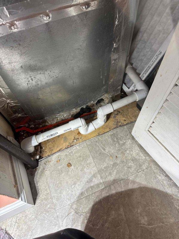 Completed repipe of furnace condensation drain system. Installed new PVC drainage piping with appropriate elbow joints to properly channel condensate away from the HVAC unit, addressing visible moisture damage at the equipment base and preventing further deterioration of the surrounding floor area.
