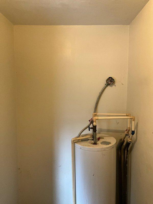 Conducted site assessment at residence where mother was present on behalf of Travis and his wife. Property currently has no existing HVAC system or ductwork, with heating solely dependent on wood burning. Documented current setup including water heater installation and available utility spaces to prepare comprehensive proposal for complete HVAC system installation with full ductwork.