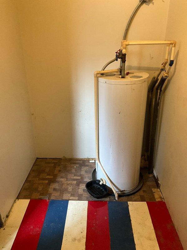 Conducted site assessment at residence where mother was present on behalf of Travis and his wife. Property currently has no existing HVAC system or ductwork, with heating solely dependent on wood burning. Documented current setup including water heater installation and available utility spaces to prepare comprehensive proposal for complete HVAC system installation with full ductwork.