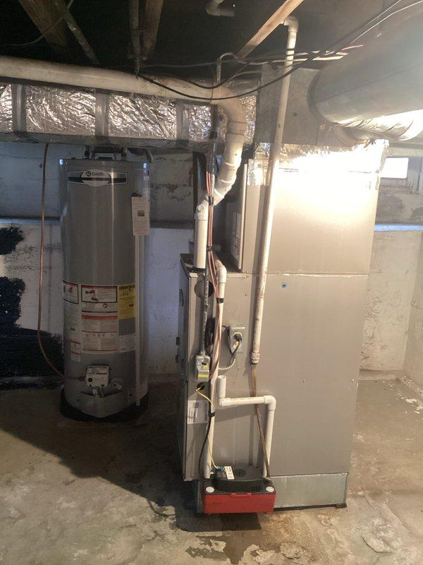 Performed routine heating maintenance on customer's furnace system. Inspected interior components including copper lines, connections, and PVC venting. All equipment appeared in normal working condition with no issues identified in both the furnace unit and adjacent water heater setup.