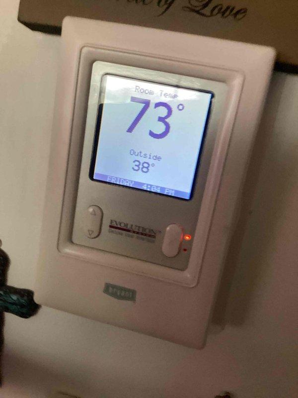 Performed routine maintenance on dual-system heating setup including outdoor heat pump and programmable thermostat. Inspected primary unit components, verified proper operation with thermostat showing room temperature of 73° and outside temperature of 38°. Both systems functioning correctly after addressing customer's concern about unusual heating behavior.