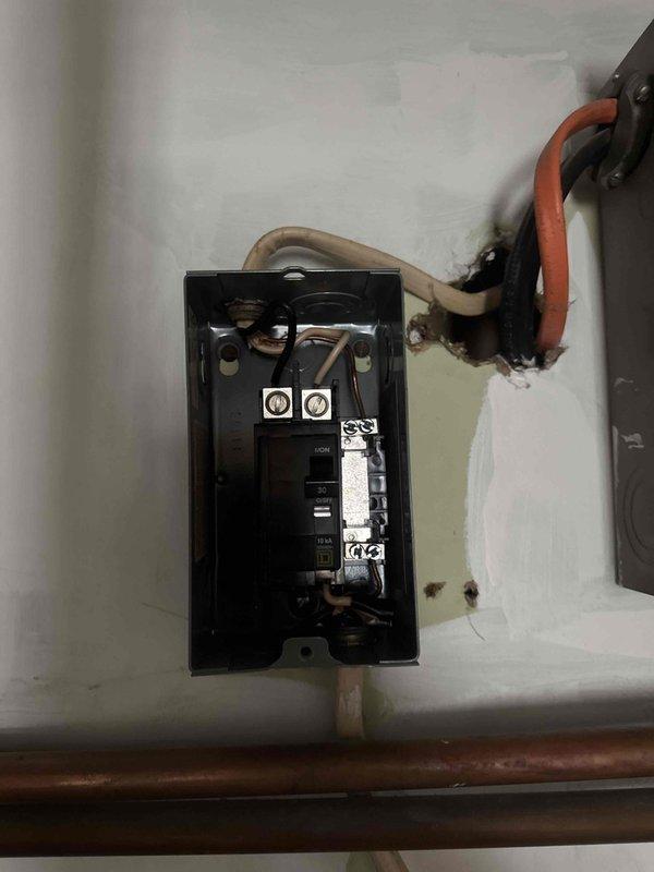 Inspected and identified an improperly installed electrical junction box connected to plumbing system. Documented evidence of potential electrical hazards including exposed wiring, improper wall penetrations, and signs of heat damage where wires enter the box. Recommended immediate professional electrical service to address safety concerns and ensure code compliance.