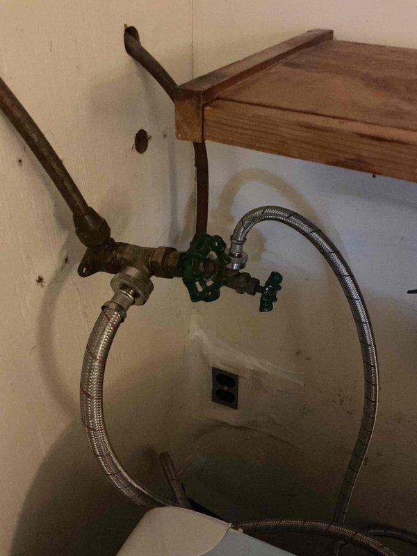 Responded to leak in washer connection valve. Upon inspection, found corroded copper pipe with failing valve assembly behind washing machine. Replaced damaged valve assembly and installed new braided stainless steel supply lines. Also leveled washing machine as requested by customer to prevent future stress on connections.