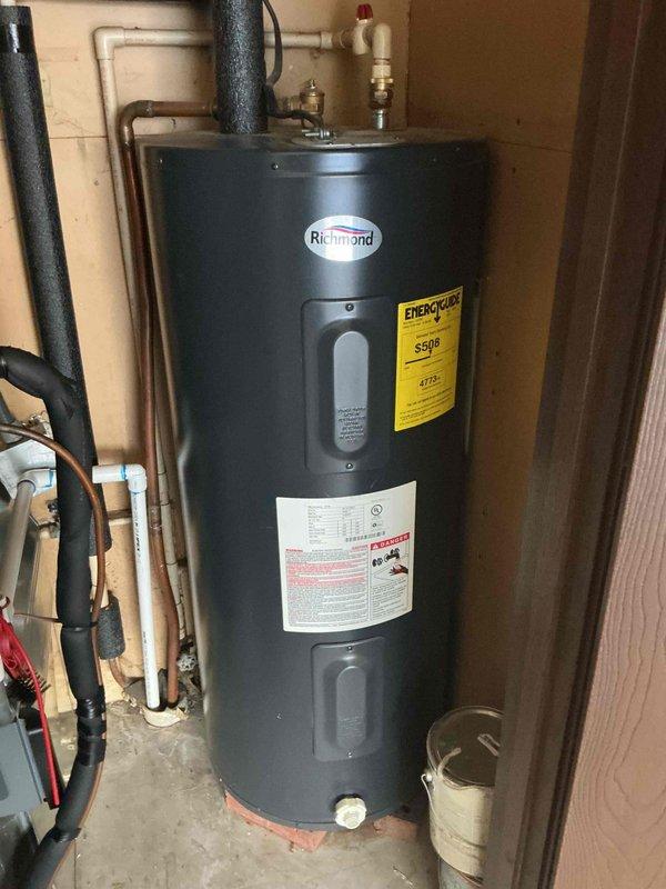 Responded to customer complaint of buzzing noise behind bathroom vanity. Upon inspection, identified water leak in supply lines with water turned off at source. Documented existing water heater installation for reference, noting proper connections of copper and PVC piping to Richmond unit.