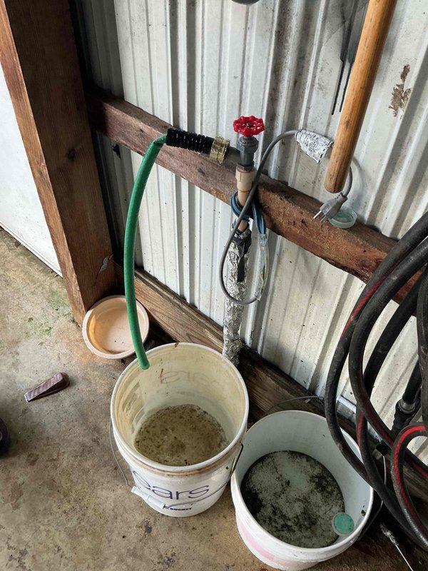 Responded to emergency call for burst water line in garage causing flooding. Customer had shut off main water valve in yard. Located and repaired damaged pipe section against corrugated metal wall, installed new valve assembly with proper fittings, and collected overflow water in buckets during repair process. Restored water service and verified proper operation with no leaks.