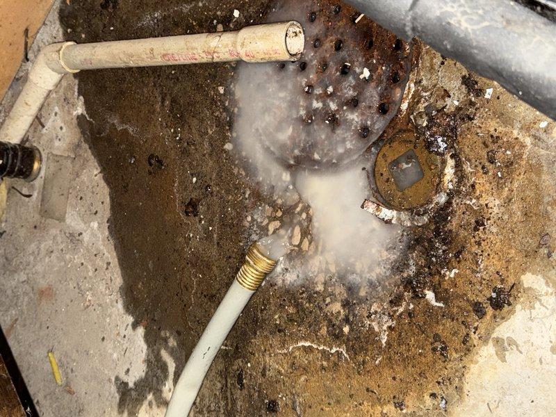 Diagnosed and serviced water heater experiencing temperature fluctuations. Identified dual thermostat system requiring reset to maintain consistent temperature. Inspected floor drain area showing mineral deposits and possible water damage, suggesting previous leakage issues that may be contributing to system performance problems.