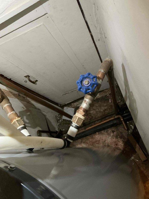 Responded to service call for frozen pipes. Located water shutoff valve in yard requiring specialized tool for access. Successfully shut off water supply, thawed frozen pipes, and inspected copper piping system for damage. Verified proper function of the blue manual valve with star-shaped handle and checked all connections for leaks after restoration of water service.