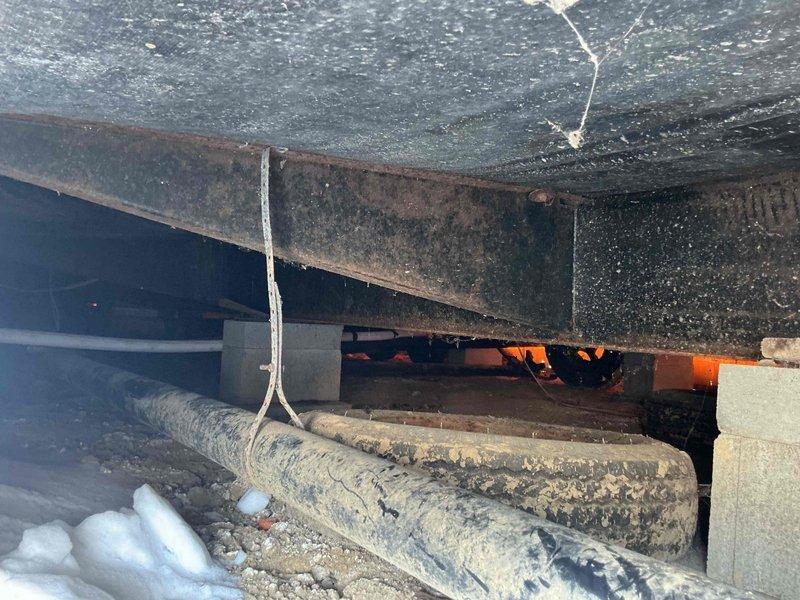 Inspected crawlspace for reported frozen pipes and confirmed presence of frost/ice accumulation on insulated piping. Observed deteriorated heat tape that requires replacement. Recommended installation of new heat tape system to prevent future freezing issues.