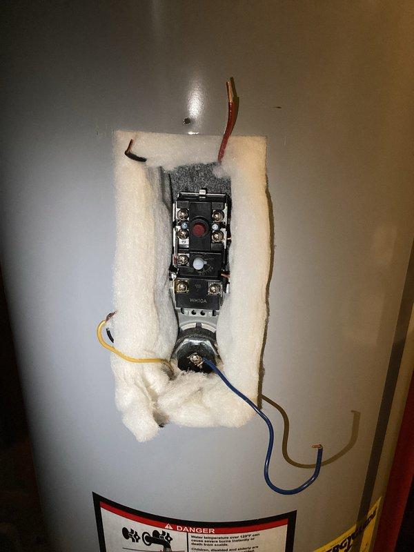 Responded to callback regarding water heater reset button repeatedly tripping. Inspected electrical components including thermostat control/relay switch and terminal connections. Accessed internal electrical control mechanism by removing cover panel and pulling back insulation. Examined wiring connections (red, yellow, blue, and black wires) to diagnose cause of thermal cutoff activation.