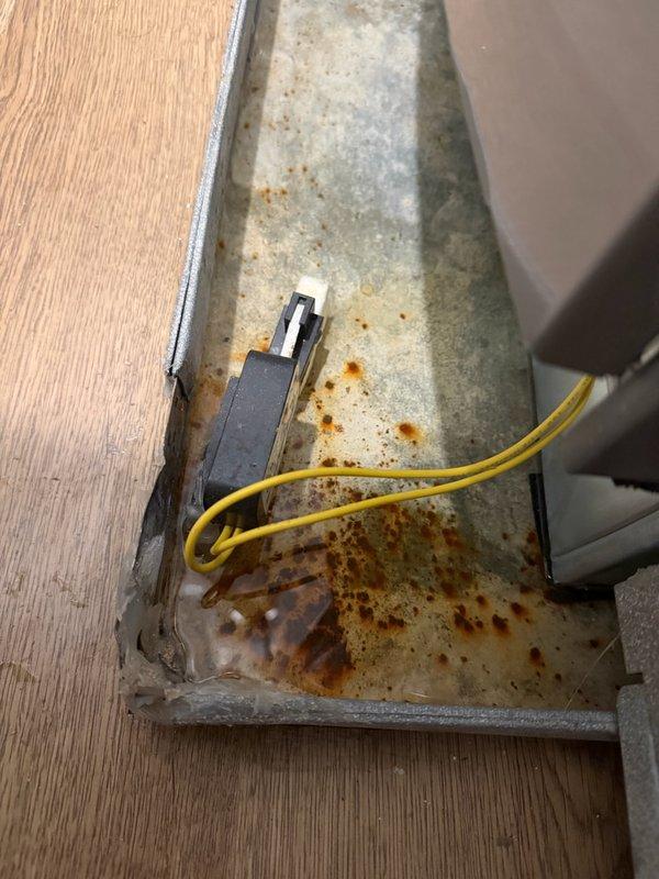 Inspected two leaking furnaces and identified significant corrosion on the drain pan of the upstairs unit. Documented extensive rust damage on metal condensate tray and surrounding components. The upstairs drain pan appears to be improperly positioned, contributing to the leakage issue.