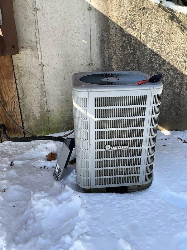 Conducted site assessment for replacement of aging Amana HVAC system experiencing operational issues. Evaluated existing outdoor condensing unit positioned on snow-covered ground with visible weathering. Identified optimal location for new return air installation in laundry room area adjacent to main living space. Customer requesting Trane equipment for the replacement system.
