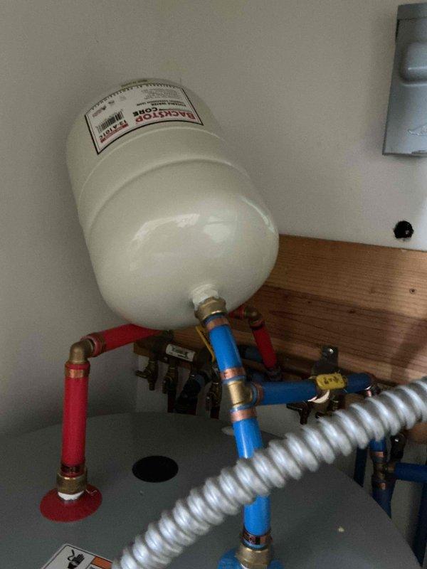 Responded to service call regarding improperly installed expansion tank on A.O. Smith ProLine water heater. Found expansion tank mounted with inadequate support, causing it to fall over and put stress on connecting PEX lines. Secured expansion tank properly to prevent bending of water lines and ensure proper system function.