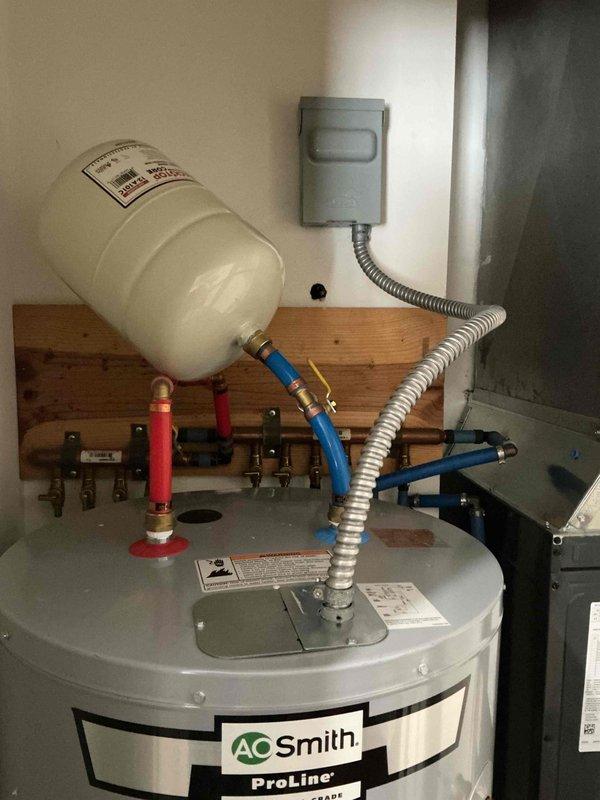 Responded to service call regarding improperly installed expansion tank on A.O. Smith ProLine water heater. Found expansion tank mounted with inadequate support, causing it to fall over and put stress on connecting PEX lines. Secured expansion tank properly to prevent bending of water lines and ensure proper system function.