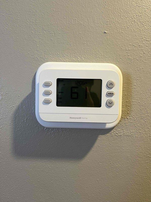 Completed installation of new heating system with Honeywell Home digital thermostat. Verified proper thermostat operation in heat mode with display showing correct temperature readings. System successfully powered up and functioning as designed.