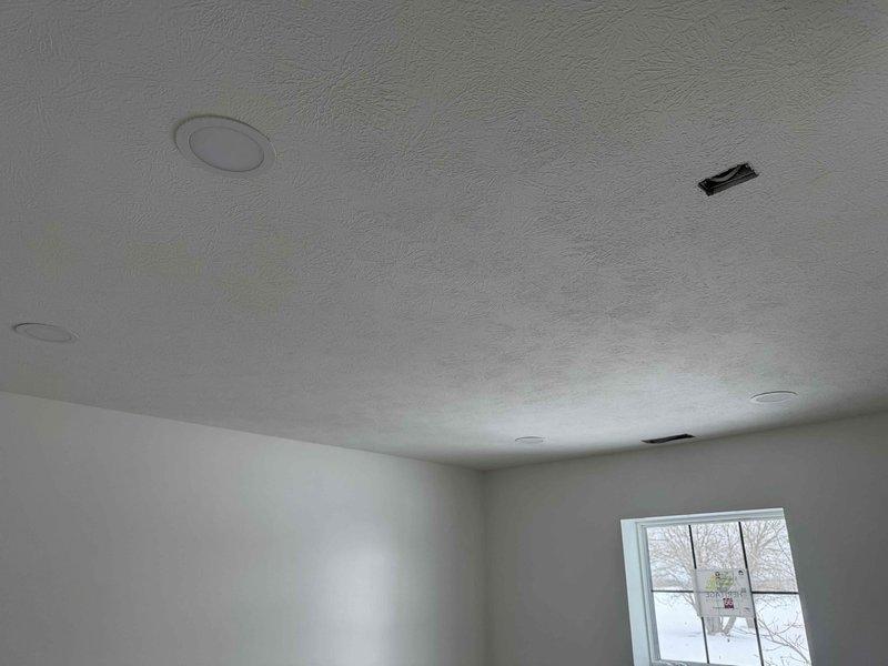 Completed rough-in electrical installation for new construction, including recessed can lights, outlets, and vanity lighting. All fixtures properly positioned and secured in textured ceiling as per specifications. Work is complete and ready for inspection.