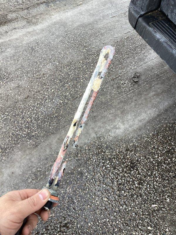 Responded to service call regarding lukewarm water heater repeatedly tripping breaker. Inspection revealed severely corroded anode rod requiring replacement and significant water damage around shower fixture with visible leakage staining surrounding tiles. Replaced anode rod and repaired leaking shower valve to prevent further water damage to wall structure.