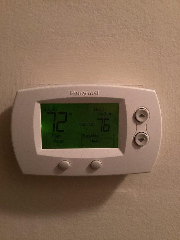 Responded to no heat complaint. Inspected Honeywell thermostat and found system was functioning properly but not reaching setpoint. Confirmed heat was calling (76°F setpoint) while actual temperature was reading 67°F, indicating a 9-degree differential. System now operating normally with indoor temperature rising appropriately.