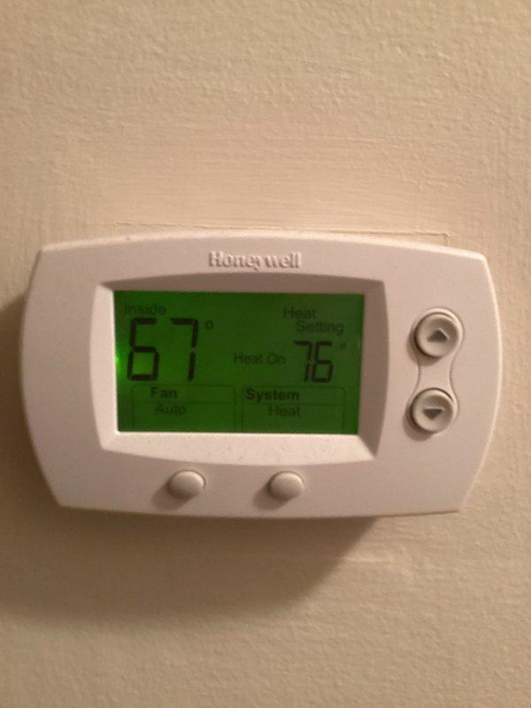 Responded to no heat complaint. Inspected Honeywell thermostat and found system was functioning properly but not reaching setpoint. Confirmed heat was calling (76°F setpoint) while actual temperature was reading 67°F, indicating a 9-degree differential. System now operating normally with indoor temperature rising appropriately.