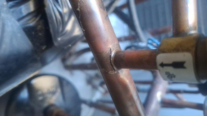 Performed routine monthly maintenance on 2-system CCHP-Heating unit. Identified error code 83 on thermostat (low pressure lockout 4) and discovered cracked copper pipe joint at valve connection. System remains operational despite the fault condition.