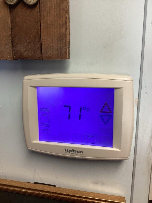 Responded to urgent service call regarding non-functioning thermostat display. Upon arrival, found Hydron thermostat with previously blank screen now operational, displaying temperature readings of 71°F and 73°F respectively. Verified heating system was producing warmth and thermostat was properly communicating with furnace. No repairs needed as system was functioning correctly at time of inspection.