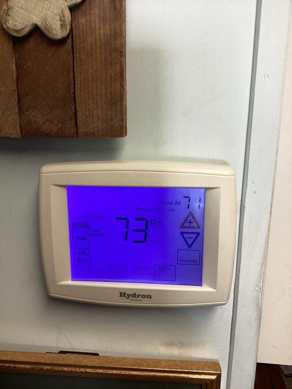 Responded to urgent service call regarding non-functioning thermostat display. Upon arrival, found Hydron thermostat with previously blank screen now operational, displaying temperature readings of 71°F and 73°F respectively. Verified heating system was producing warmth and thermostat was properly communicating with furnace. No repairs needed as system was functioning correctly at time of inspection.