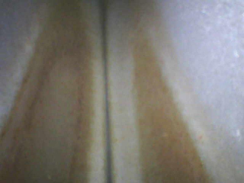 Performed second opinion inspection on furnace heat exchanger following previous contractor's claim of cracks. Visual inspection confirmed presence of cracks in heat exchanger with visible discoloration patterns along seams. Documented damage with photos showing distinct deterioration and oxidation on exchanger surfaces.