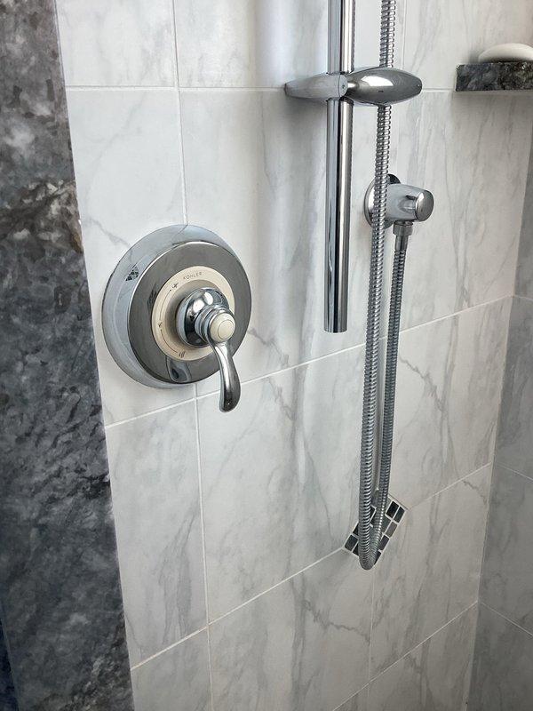 Responded to service call for sewer backup. Inspection revealed significant drainage issue affecting the foundation area, with evidence of water damage to exterior wooden trim and siding. Observed improper drainage configuration with two corrugated pipes discharging near foundation, creating a structural vulnerability where moisture has compromised the foundation-to-siding transition point.