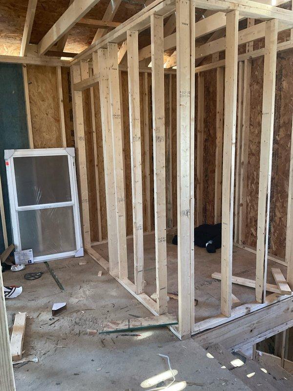 Completed site evaluation for new HVAC system installation in residential remodel currently in framing stage. Property features exposed wooden studs, unfinished plywood flooring, and high ceilings with exposed rafters. Coordinated with plumbing team for integrated mechanical systems planning.