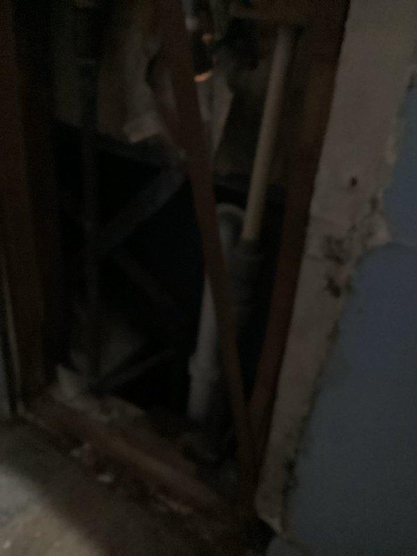 Conducted pre-inspection for bathroom renovation project involving replacement of existing tub and surround with new walk-in shower and glass doors. Examined wall cavity to assess plumbing infrastructure and photographed water heater system (Defender Safety System) with connected PVC piping to evaluate capacity and compatibility with planned installation.