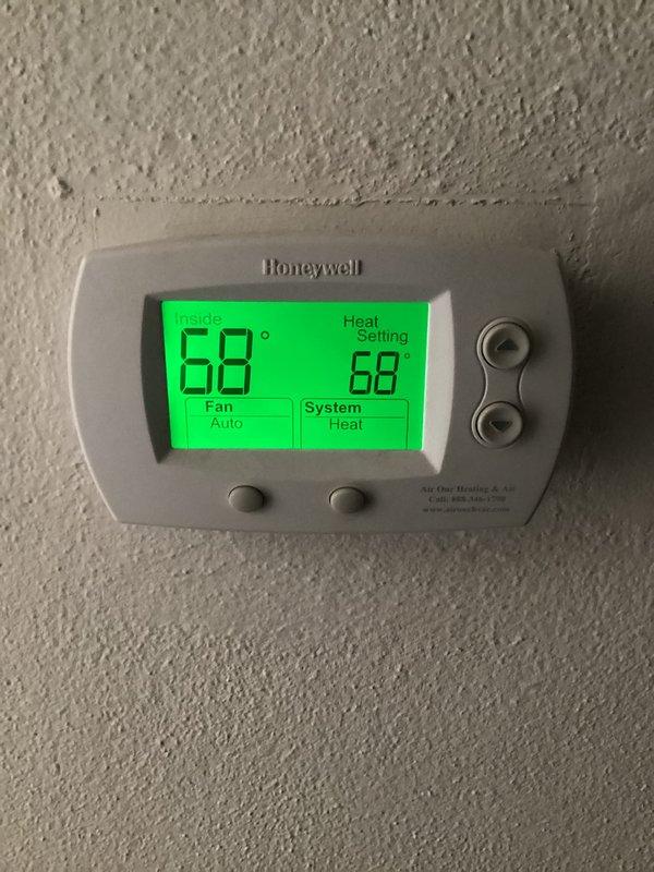 Performed monthly basic heating maintenance service at residence. Inspected Honeywell thermostat confirming proper operation in heat mode with temperature set at 68°F and fan in auto mode. Visual examination of heating system showed proper installation with appropriate ductwork and connections to water heater system.