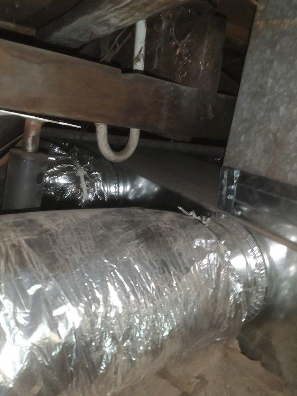 Completed ductwork renovation by removing all existing supply ducting in the crawl space due to rust issues. Installed new supply plenum and replaced deteriorated ductwork with foil-backed insulated supply runs, connecting them to the existing boots and registers which were preserved. Visual inspection confirms proper installation of the reflective foil insulation around circular ducts with secure connections at all junction points.