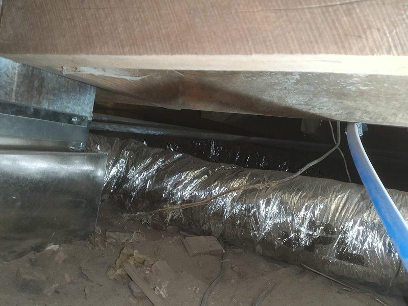 Completed ductwork renovation by removing all existing supply ducting in the crawl space due to rust issues. Installed new supply plenum and replaced deteriorated ductwork with foil-backed insulated supply runs, connecting them to the existing boots and registers which were preserved. Visual inspection confirms proper installation of the reflective foil insulation around circular ducts with secure connections at all junction points.
