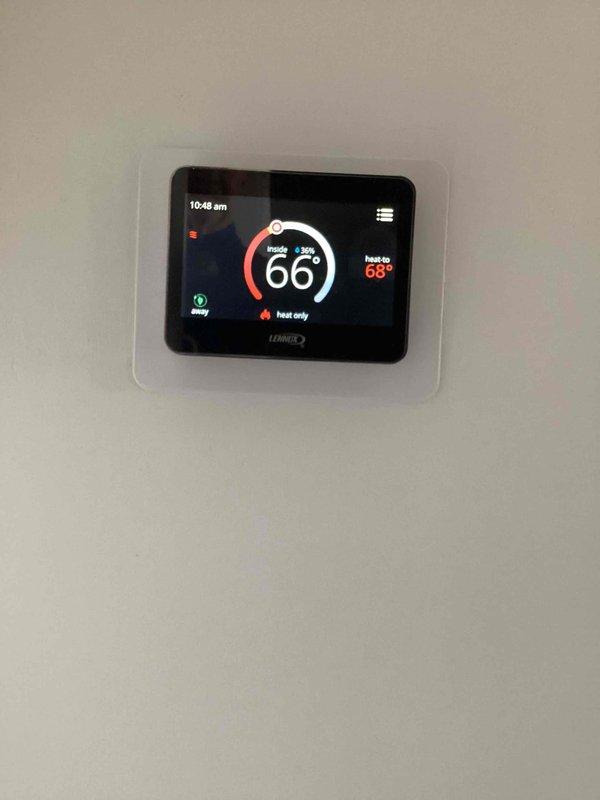 Performed complimentary tune-up service as part of maintenance plan enrollment. Inspected pressure vessel system with multiple connection points, verifying proper installation of PVC pipes and hose connections. Checked Lennox smart thermostat operation, confirming proper heat mode functionality with set point at 68° and current reading at 66°.